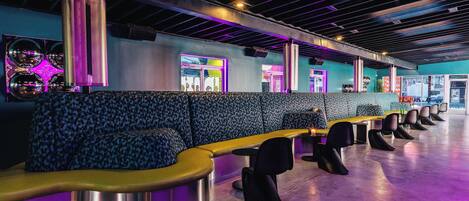 A modern lounge area with seating and a large illuminated speaker.
