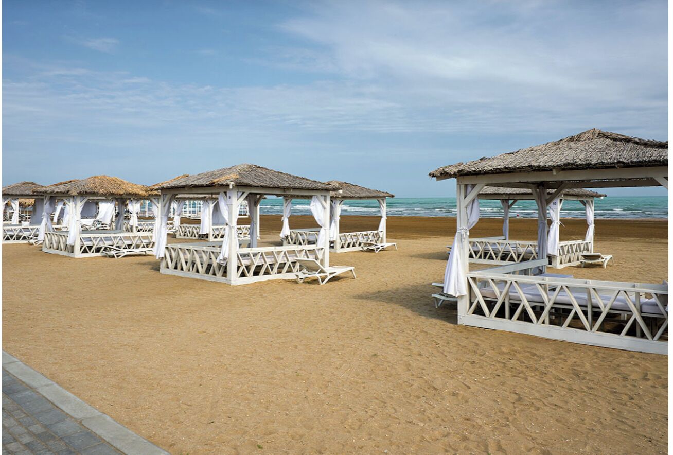 En privat strand, sort sand, gratis strandtransport, parasoller