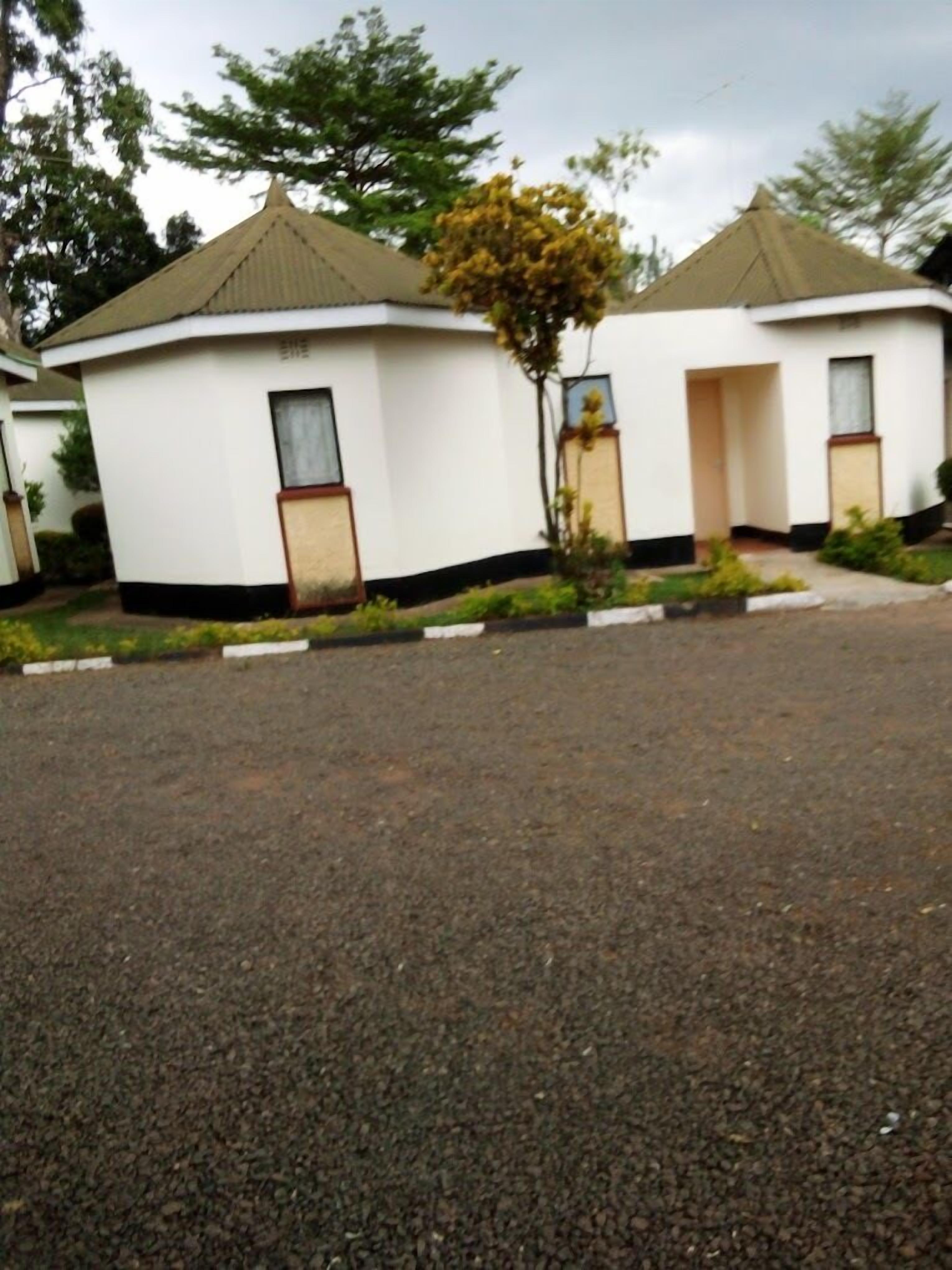 A row of small, white, single-story buildings with a flat roof and a small porch area.