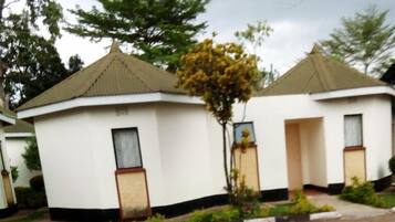 A row of small, white, single-story buildings with a flat roof and a small porch area.