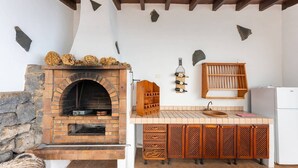 A rustic kitchen with a brick oven, wooden cabinets, and a wine rack. - Casa Café - Rural charm with all the comforts of home (Los Realejos)