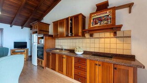 A kitchen with wooden cabinets, a microwave, and a sink. - Casa Café - Rural charm with all the comforts of home (Los Realejos)