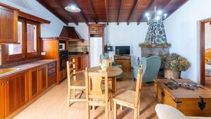 Un vaste espace de vie agrémenté de meubles en bois, d’une cheminée et d’un conduit de cheminée en pierre.