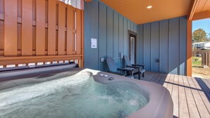 A hot tub area with a wooden deck, a door, and a chair. - *Charming 4BD Lodge Near TOWN! Fire Pit + Hot Tub* (Sevierville)