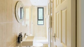 A modern bathroom with a toilet, sink, and mirror. - Central London 2BR Near Piccadilly Circus for 4 (London)
