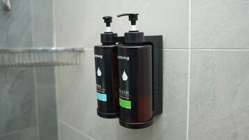 Shower, pengering rambut, handuk, dan tisu toilet