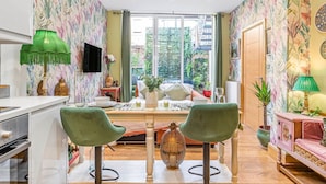 A compact living space with a kitchenette, a dining area, and a seating area with a view of the outdoors.