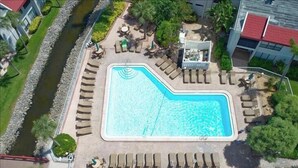 An aerial view of a swimming pool surrounded by lounge chairs and a small building. - Runaway Bay 209 - Waterview Condo with Heated Pool and Tennis (Bradenton Beach)