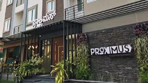 A multi-story hotel with balconies, a restaurant named "Sahib" at the ground level, and a sign for "Proximus" on the facade. - Proximus Boutique Hotel Apartments (Bengaluru)