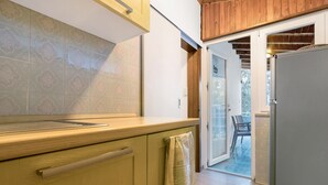 A kitchen with wooden cabinets, a countertop, and a refrigerator. - Apartment 'Bungalow Pit Stop' with Lake View, Wi-Fi and Air Conditioning (Brenzone sul Garda)