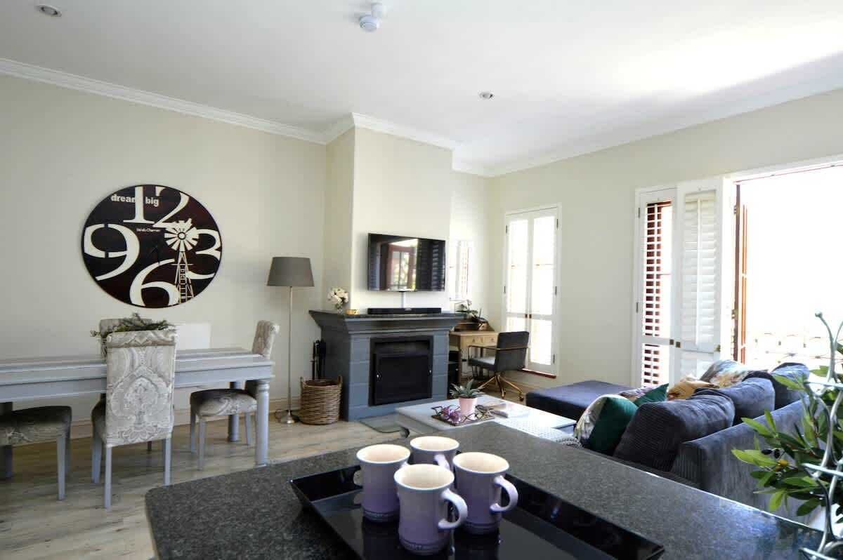 A living room with a fireplace, a dining area, and a seating area with a sofa.