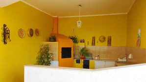 A kitchen with yellow walls, a white countertop, and various kitchen items. - Typical House with private pool (Siracusa)