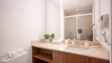 Et moderne badeværelse med et stort spejl, vask og toilet.