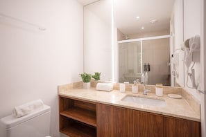 A modern bathroom with a large mirror, a sink, and a toilet. - For You Moema (São Paulo)