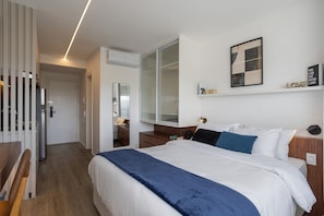 A modern hotel room with a large bed, a wardrobe, a desk, and a mirror. - For You Moema (São Paulo)