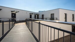 A modern building with a covered walkway and multiple rooms. - We rooms Shortstay  (Karben)