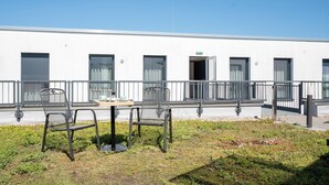 A modern building with a white exterior, multiple windows, and a balcony with metal railings. - We rooms Shortstay  (Karben)