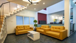 Ein modernes Wohnzimmer mit einer Sofagarnitur, einem Couchtisch und einer Treppe.