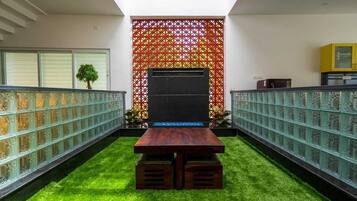 Un intérieur moderne avec une table centrale, des panneaux de verre décoratifs et un mur orné de motifs.