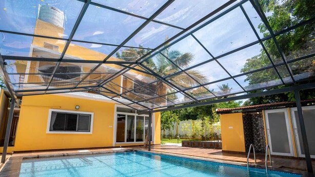 Ein Innenpool mit Glasdecke, gelben Wänden und freiem Blick auf die Umgebung.