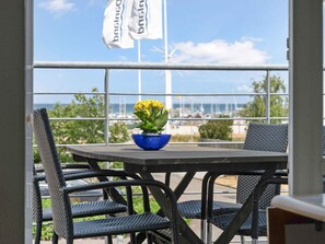 A balcony with a table, chairs, and a potted plant. - 5 Star Holiday Home in Glesborg (Glesborg)