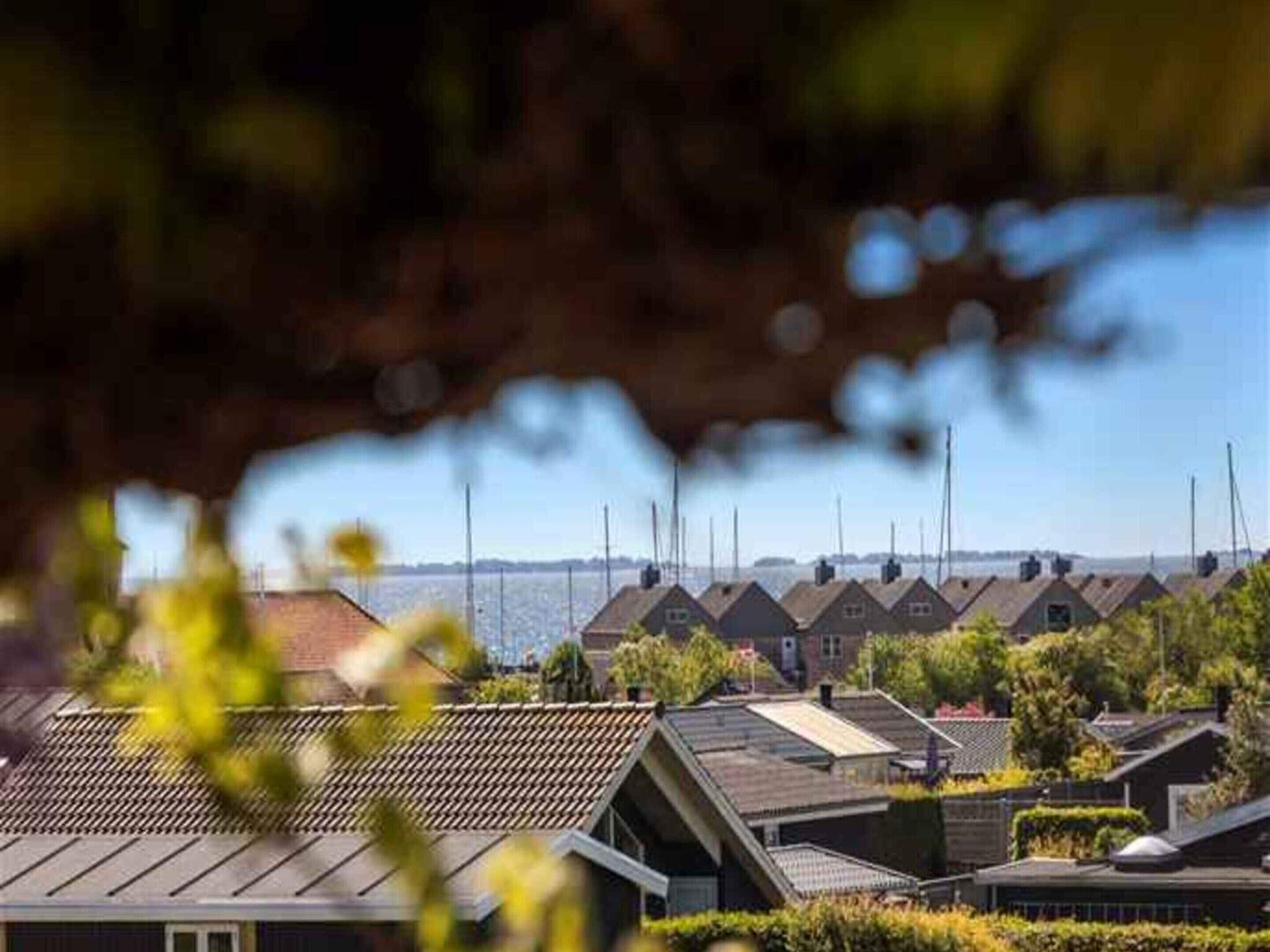 A row of houses with sloped roofs, likely residential, with a clear view of the sky and a distant horizon.