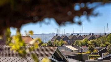 A row of houses with sloped roofs, likely residential, with a clear view of the sky and a distant horizon.
