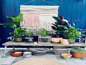 A rustic outdoor setting with a wooden table displaying various potted plants and woven baskets. - 4 Star Holiday Home in Karrebaeksminde (Karrebæksminde)