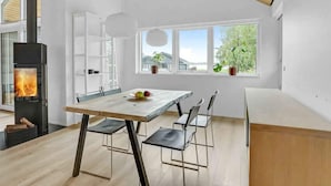 A modern kitchen with a central island, a built-in stove, and large windows offering a view of the outdoors. - 5 Star Holiday Home in Sunds (Sunds)