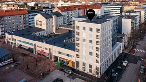 A multi-story building with a flat roof, a sign for 'BORG' on top, and a 'RADIO PORT' sign on the ground floor. - Borg Loft Apt Itäpuisto (Pori)