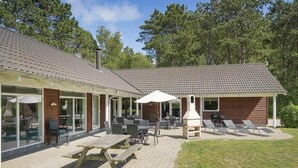 Eine Terrassenfläche mit Sitzgelegenheiten und einem Holzofen.