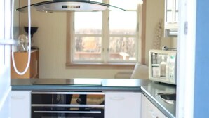 Eine Küche mit Geschirrspüler, Backofen und Mikrowelle.