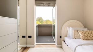 Una camera da letto con un letto, una finestra e una porta che dà su un balcone.