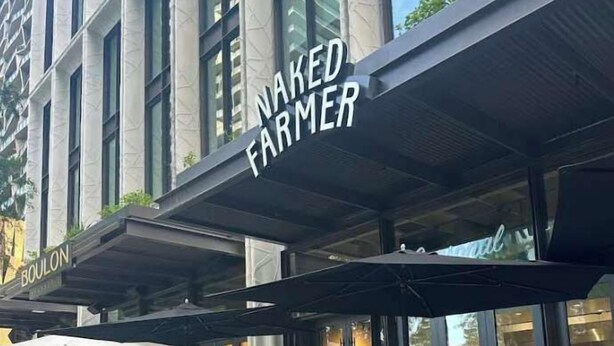 Exterior del restaurante Naked Farmer, con mesas al aire libre y un diseño arquitectónico moderno.