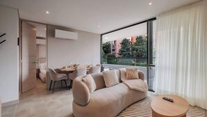 A modern living room with a sofa, coffee table, and dining area.