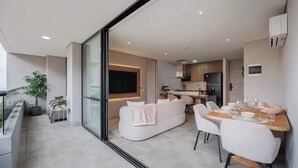 A modern apartment with a dining area, kitchen, and living space.