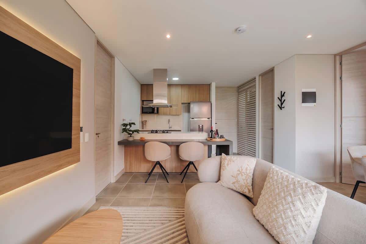 Un salon moderne avec un canapé et un téléviseur à écran plat fixé au mur.