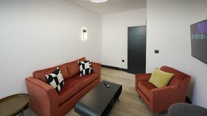 Ein modernes Wohnzimmer mit einer Couch, einem Couchtisch und einem Sessel.