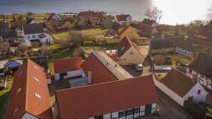 A coastal village with traditional houses, a clear view of the sea, and a small dock.