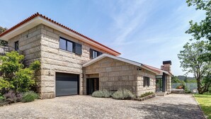 Et stenhus med garage, en overdækket veranda og en anlagt indkørsel.