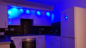 A kitchen with white cabinets, a stainless steel oven, and a refrigerator. - Charming Liverpool Home With Gardens and Parking (Liverpool)