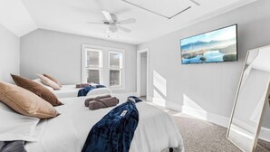 A bedroom with a bed, pillows, a ceiling fan, a window, and a painting on the wall. - Tremont · Group Suite · Prking · Mins to DT · Wifi (Cleveland)