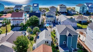 Una zona residenziale lungo la costa, con case, una piscina e una spiaggia sullo sfondo.