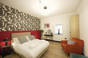 A modern bedroom with a large bed, a desk, a chair, and a window. - Sixty Aparthotel 2bed, Central Cardiff + Parking (Cardiff)