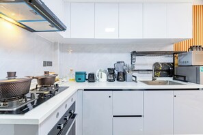 Eine moderne Küche mit Gaskochfeld, Kaffeemaschine und Mikrowelle.