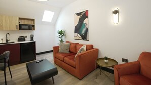 A modern apartment with a kitchen, a sofa, a coffee table, and a dining area. - Sixty Aparthotel 2bed, Central Cardiff + Parking (Cardiff)