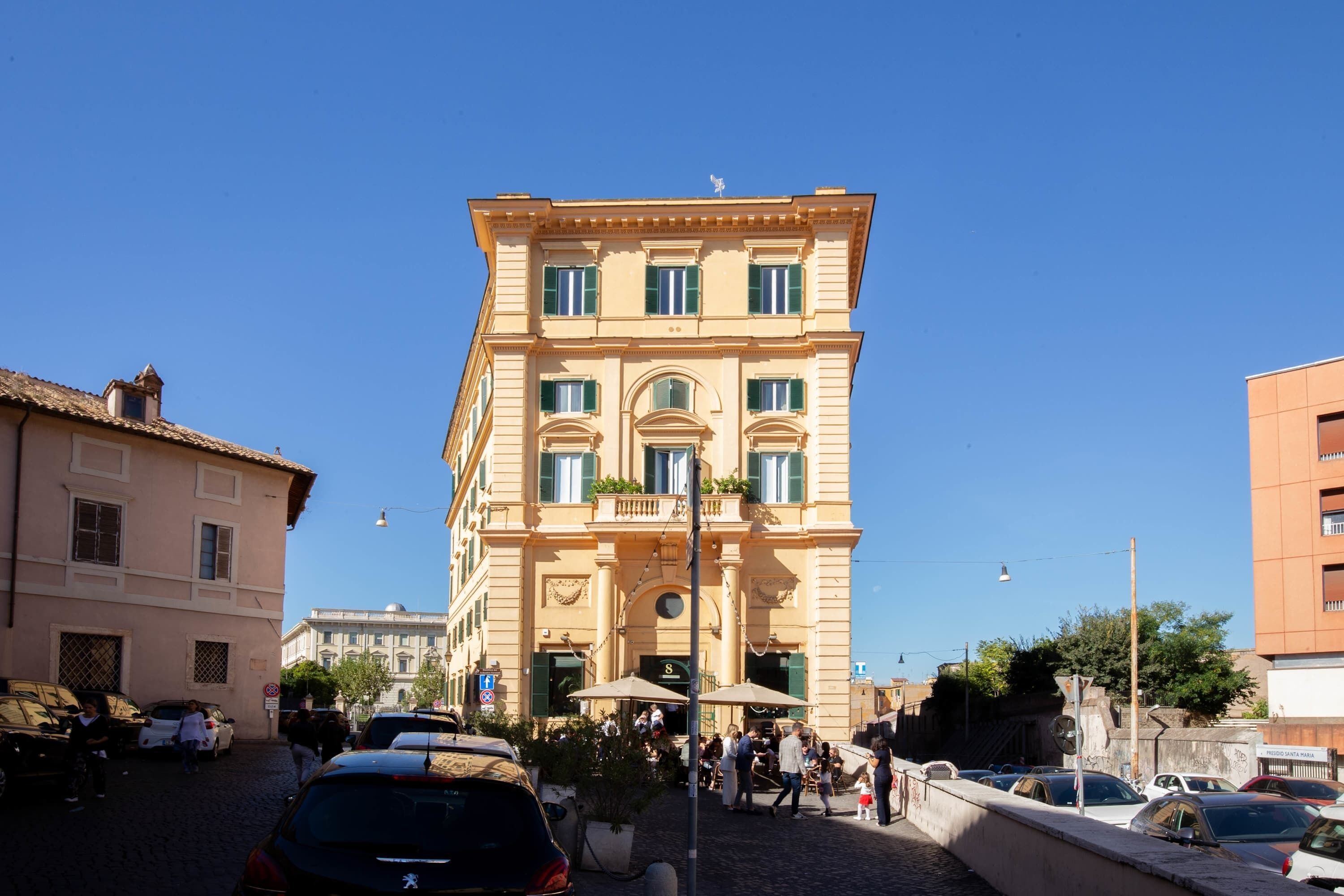 A multi-story building with a classic architectural style, featuring a central entrance with a canopy and a sign above it.