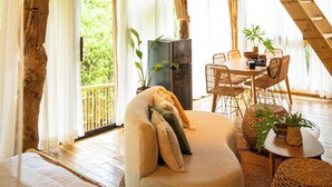 Un intérieur en bois comprenant un canapé, une table à manger, des chaises et un luminaire suspendu.