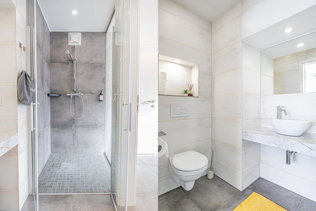 Une salle de bain moderne dotée d’une douche à parois de verre, de toilettes et d’un lavabo avec un plan de travail en marbre.