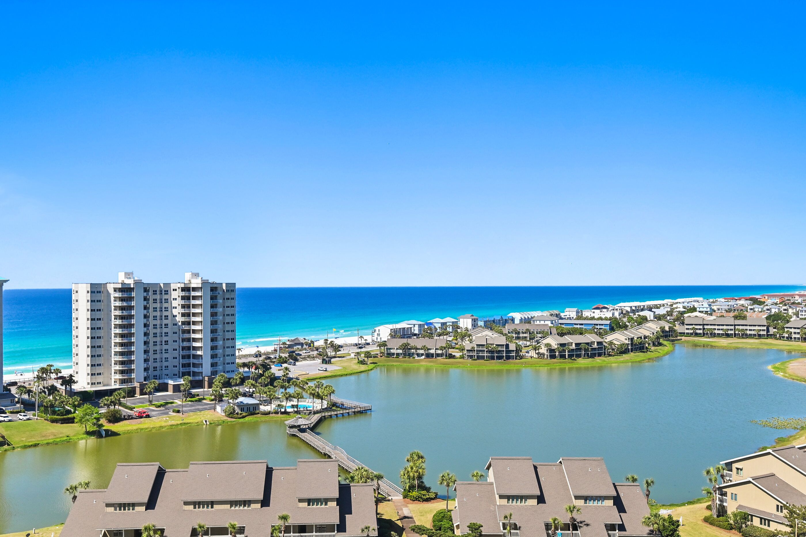A coastal resort with high-rise buildings, a marina, and a clear view of the ocean.